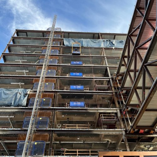 A DOC® Hoist is installed above a series of DOC® Loading Decks on inner floors of a high-rise construction project.