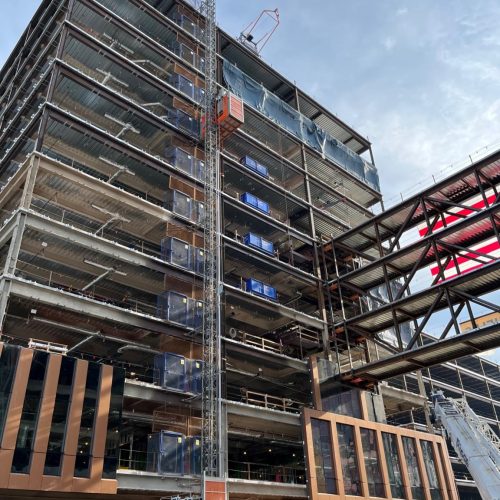 A stack of DOC® Loading Decks installed beneath a DOC® Material Hoist, providing a completely separate material hoisting process to keep the tower crane on task.