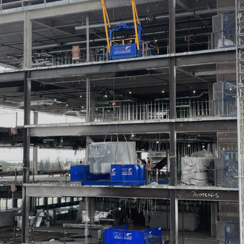 DOC® Loading Decks installed underneath a DOC® Material Hoist on an inner floor of the building. Used for moving mechanical and curtain wall as the tower crane builds the structure.